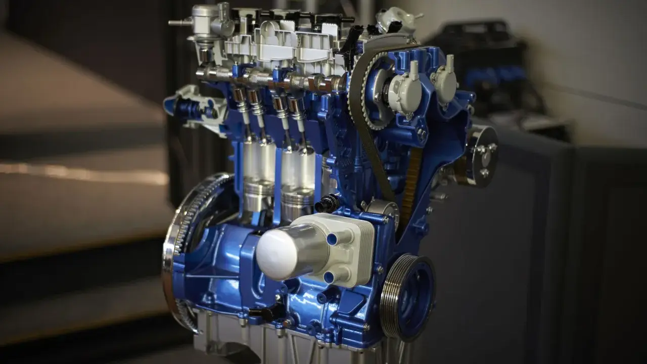 Przekrój silnika 1.0 Ecoboost w kolorze niebieskim, z widocznymi tłokami i paskiem rozrządu.
