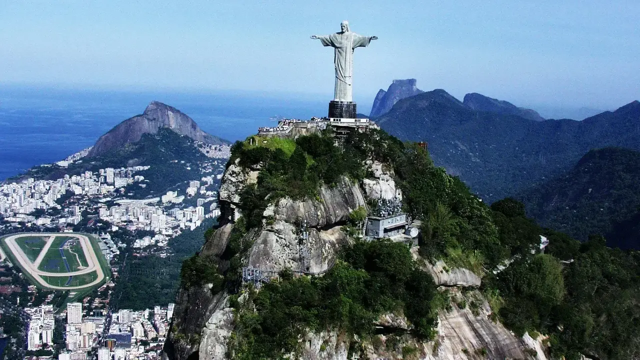 Majestatyczny pomnik Rio de Janeiro Jezus góruje nad miastem i oceanem, otoczony bujną zielenią i skalistymi szczytami.