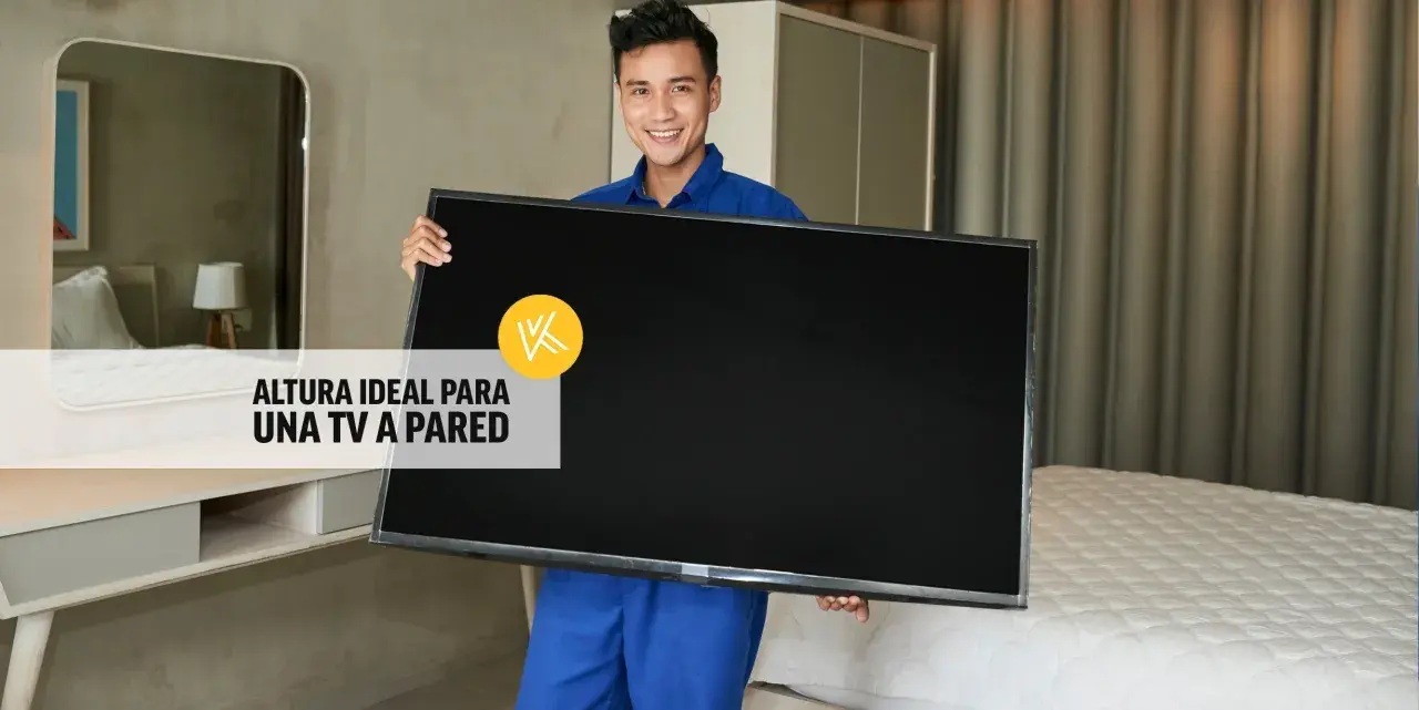 Hombre sonriente sostiene un televisor, listo para instalarlo. La altura ideal para un mueble de TV suspendido es clave.