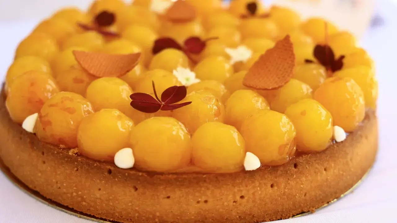 Tarte aux abricots, une spécialité de Metz, garnie de fruits brillants et de décorations délicates.