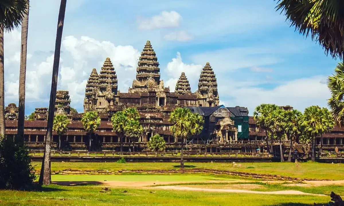 Angkor Wat, Cambodia, a majestic temple complex, bathed in sunlight. A gay couple enjoys the view, embracing the beauty of this historic site.