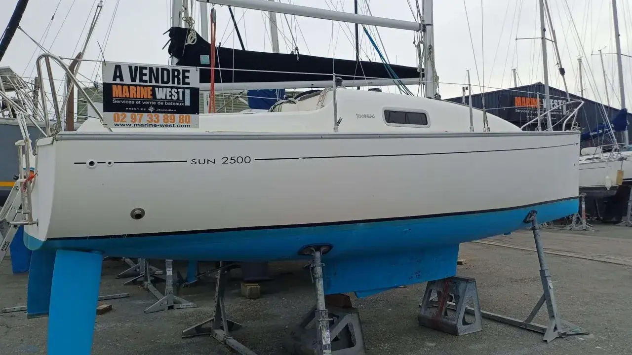 Bateau Sun 2500 à vendre, avec sa quille bleue et sa voile noire. Marine West propose ce voilier.