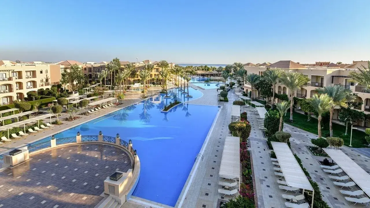 Luksusowy resort Jaz Aquamarine z basenami o turkusowej wodzie, palmami i budynkami hotelowymi.