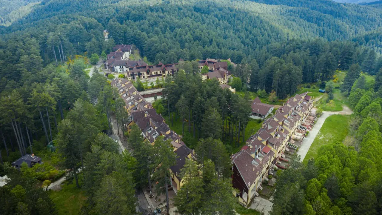 Villaggio Mancuso immerso nel verde, con case a schiera e palazzine circondate da fitti boschi di conifere.
