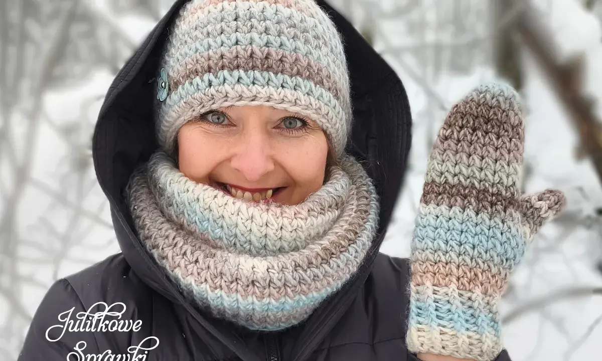 Uśmiechnięta kobieta w zimowym otoczeniu prezentuje ręcznie robione wzory czapek na szydełku i rękawiczki.