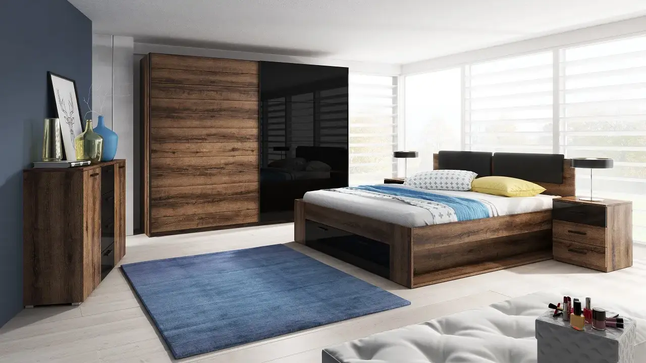 Dormitorio con muebles oscuros de madera y cristal negro. Pared azul oscuro, alfombra azul y cama con ropa de cama blanca y azul.