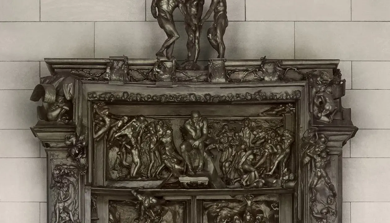 Detaljerad bronsrelief av helvetets portar, med figurer i dramatiska poser.