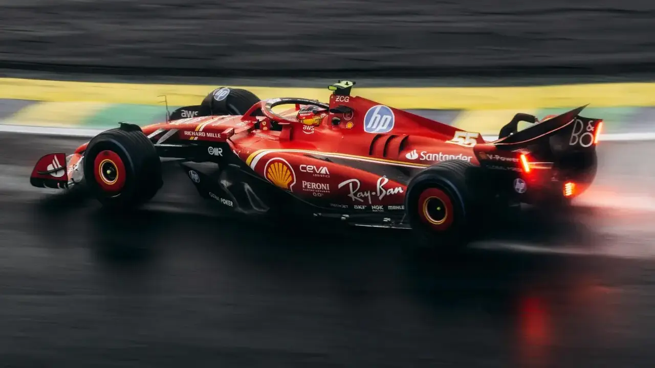Czerwony bolid F1 2018 z numerem 55 na torze, w deszczu.
