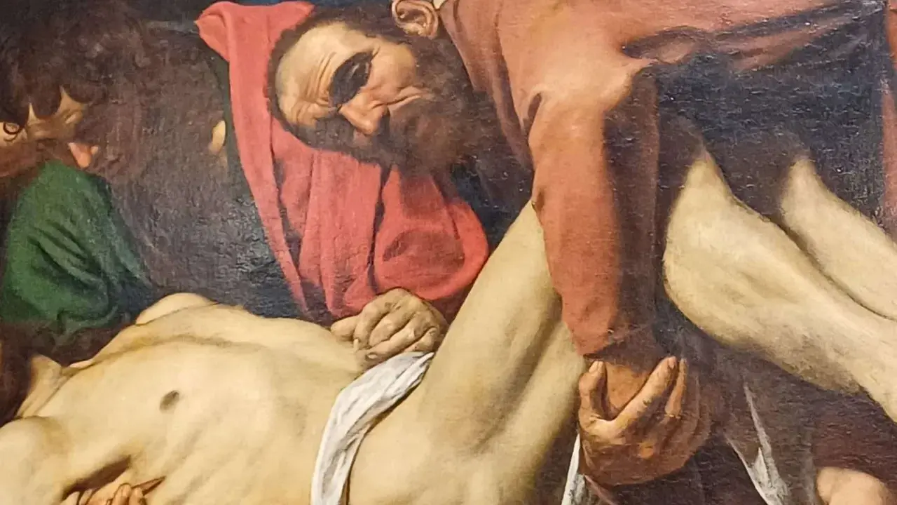 Détail de la mise au tombeau par Caravage : des hommes portent le corps du Christ, le visage marqué par la douleur.