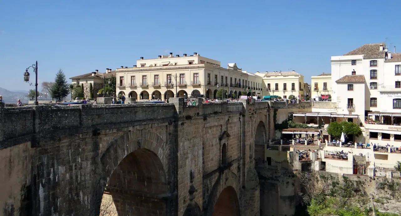 Ein perfekter tagesausflug seville: die Puente Nuevo in Ronda, mit Häusern, die sich an die Felsen klammern.