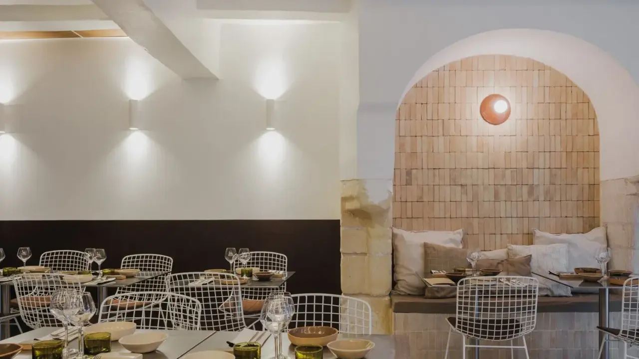 Ambiance chaleureuse dans ce qui semble être le meilleur resto à Tours. Tables dressées, chaises design et mur en briques apparentes créent une atmosphère accueillante.