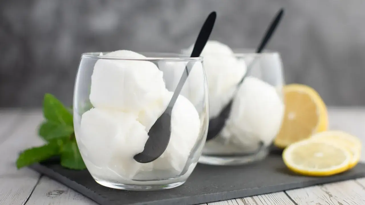 Deux verres de sorbet citron, parfaits pour un cocktail Colonel rafraîchissant, avec des quartiers de citron et de la menthe.