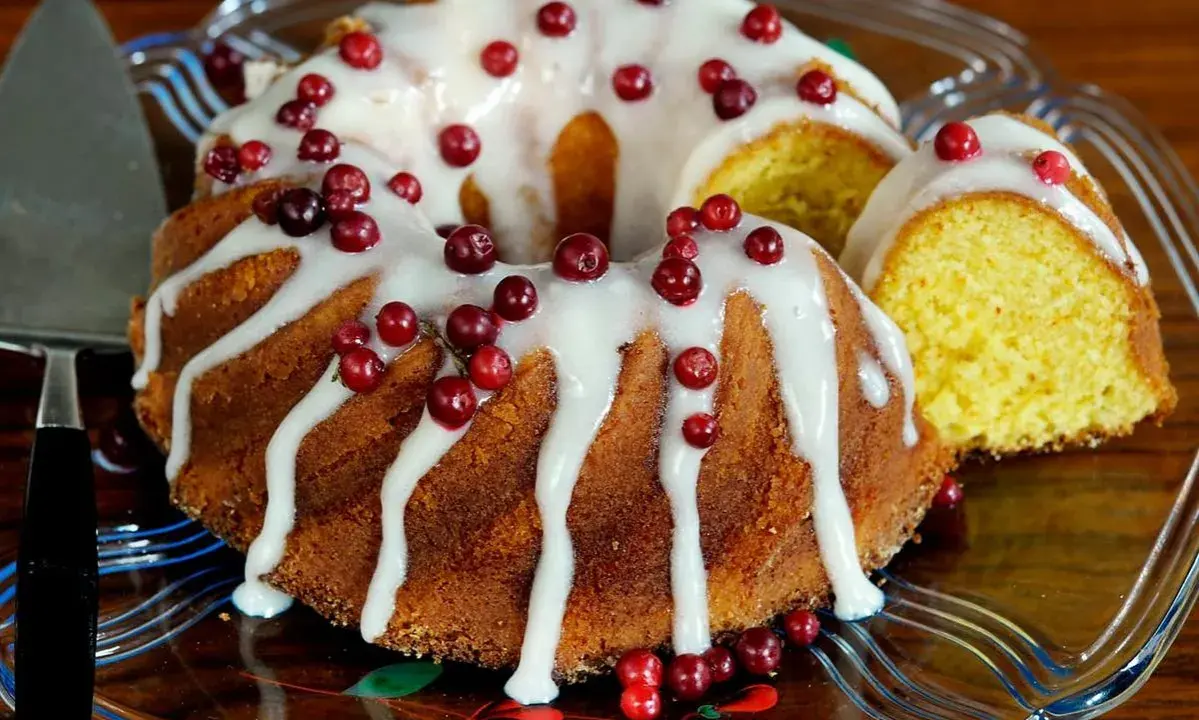 En saftig sockerkaka med vit glasyr och röda lingon, en perfekt höstkaka.