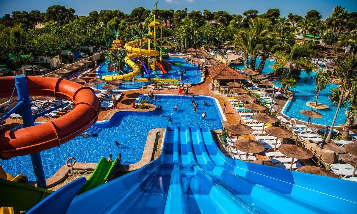 Parque acuático con toboganes, piscinas y palmeras. Ideal para hoteles temáticos para niños.
