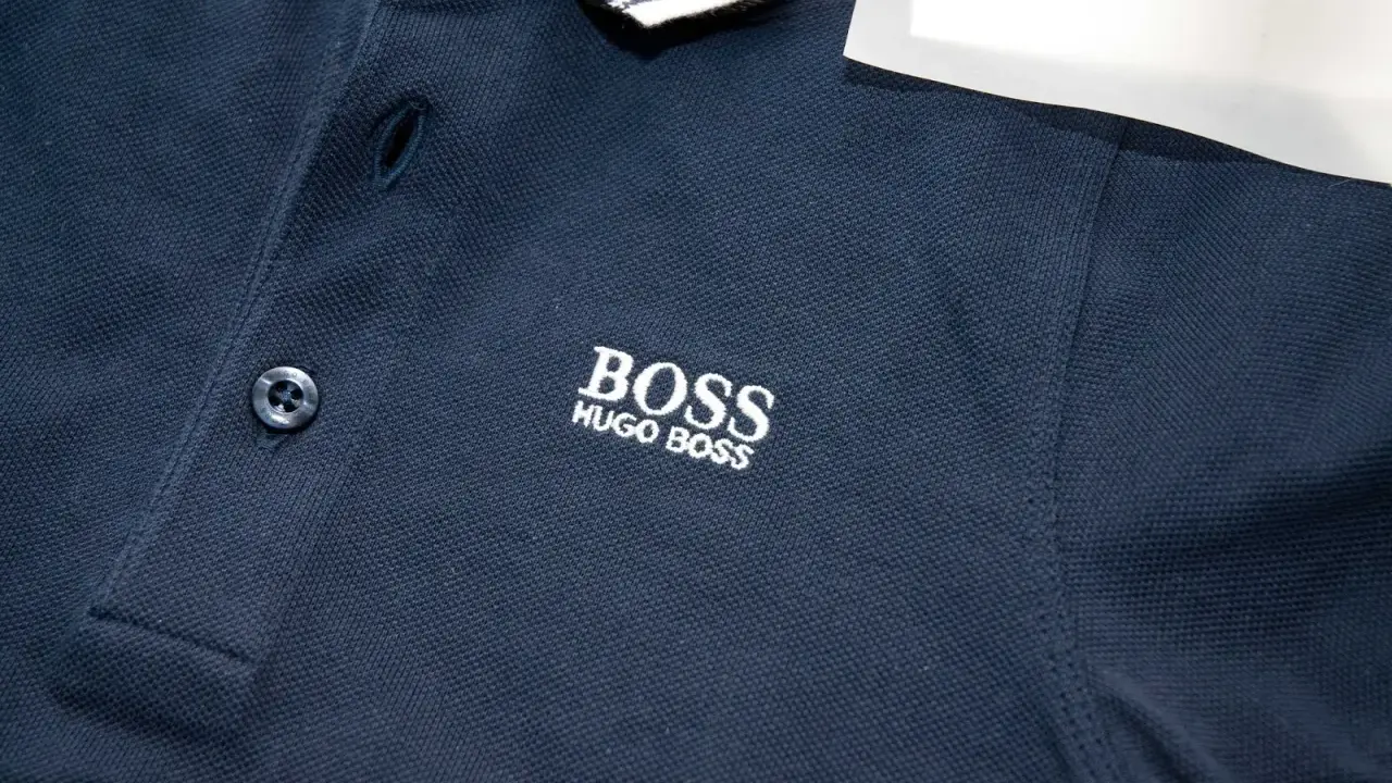 Granatowa koszulka polo z haftowanym logo BOSS HUGO BOSS. Widoczna oryginalna metka Hugo Boss.