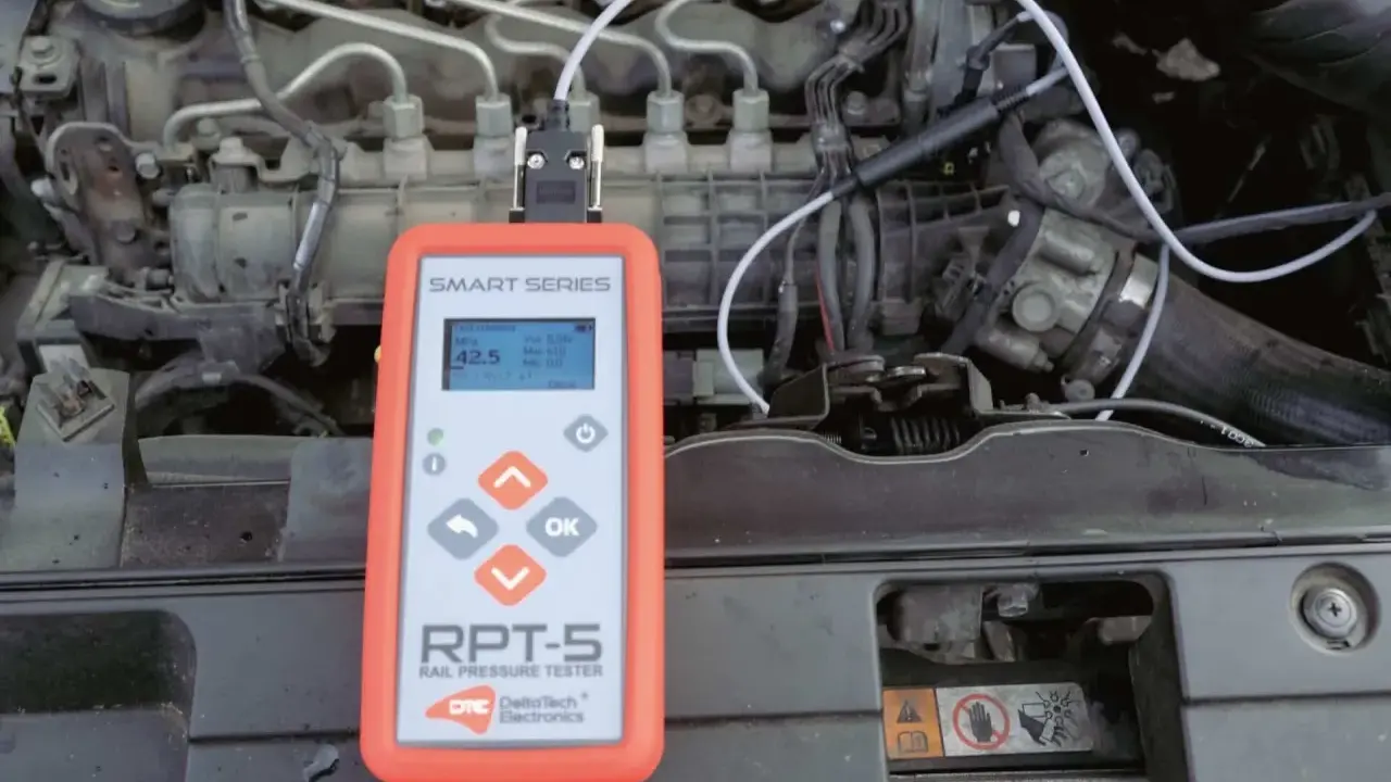 Tester ciśnienia paliwa RPT-5 podłączony do silnika. Urządzenie pomaga jak sprawdzić regulator ciśnienia paliwa, pokazując odczyty na ekranie.