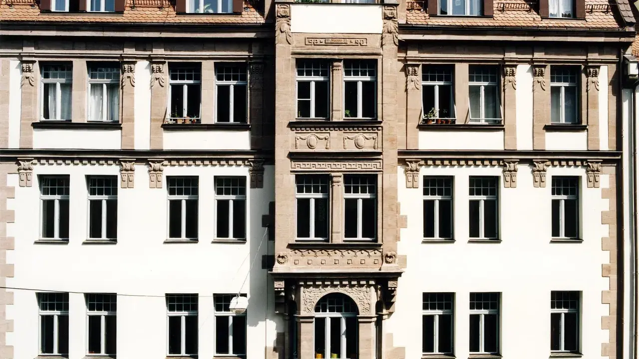 Fassade eines Altbaus mit vielen Fenstern. Hier könnte eine energetische Sanierung Beratung ansetzen, um das Gebäude fit für die Zukunft zu machen.