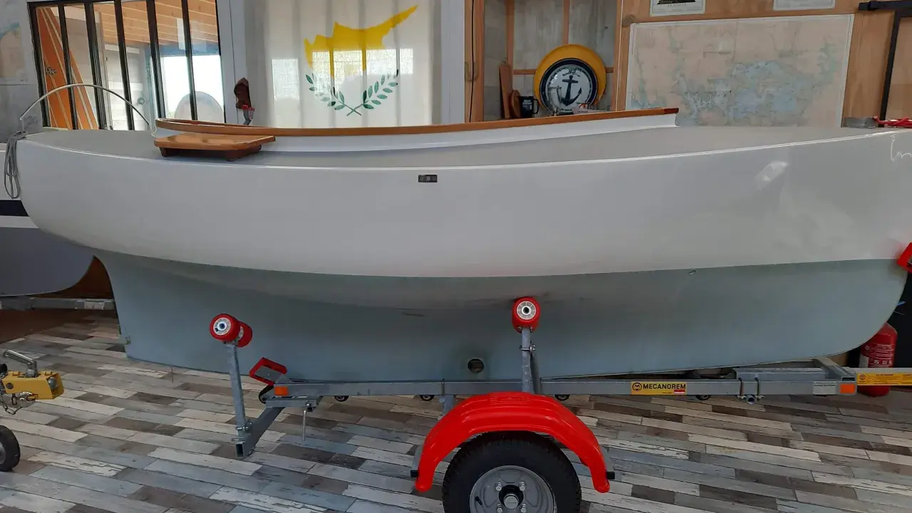 Bateau blanc sur remorque, prêt pour l'aventure. Le drapeau chypriote flotte, rappelant les eaux bleues. Un **pabouk 360** attend son prochain voyage.