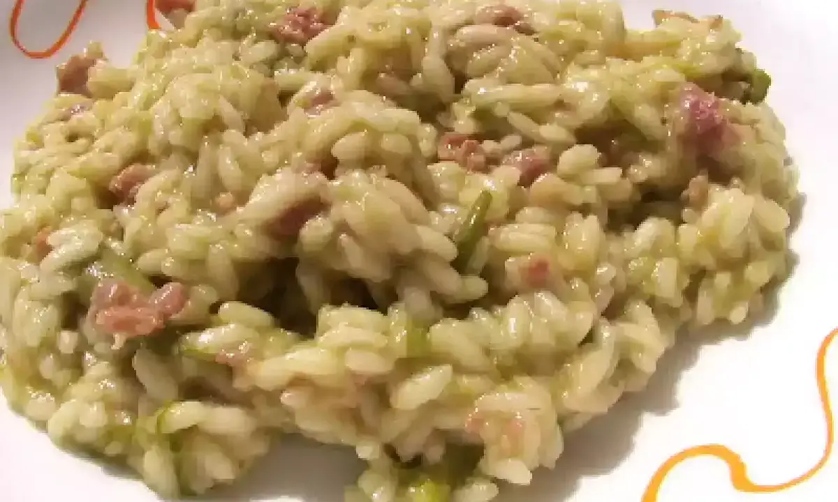 Un cremoso risotto asparagi e salsiccia, un piatto ricco di sapore e colore, pronto per essere gustato.
