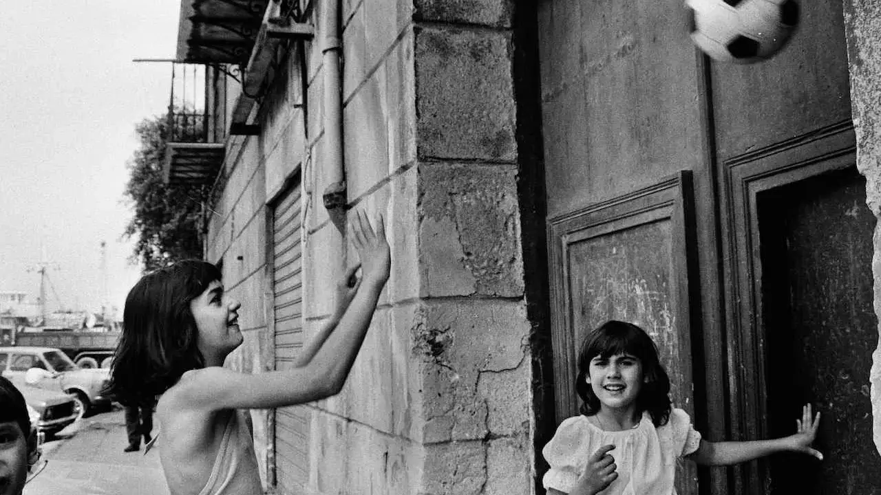 Bambine giocano a pallone in strada, un momento catturato da una fotografa famosa italiana.
