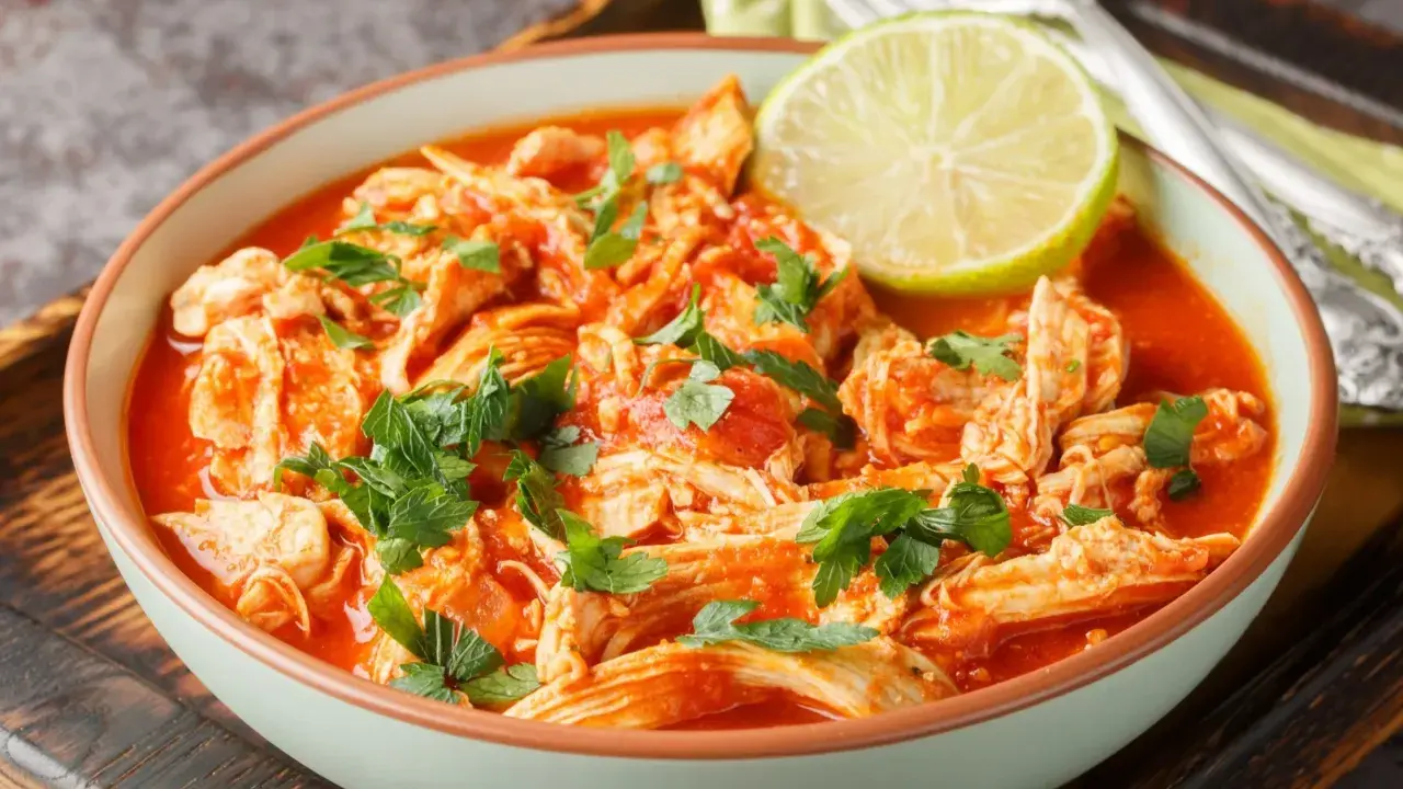 Pyszne danie z ugotowanych udek kurczaka w sosie pomidorowym, posypane natką pietruszki i udekorowane plasterkiem limonki. Idealne, gdy zastanawiasz się, co zrobić z ugotowanych udek kurczaka.
