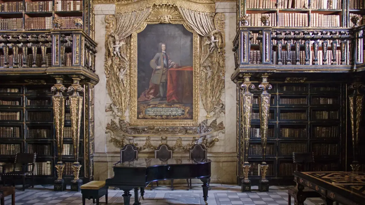 Prachtvolle Coimbra Bibliothek mit einem Flügel und einem Porträt.
