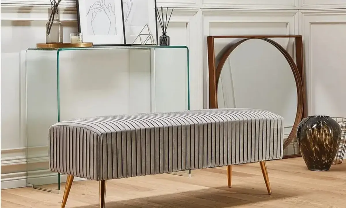 En elegant, randig bänk med guldfärgade ben. En billig bänk som ger ditt hem en lyxig känsla.