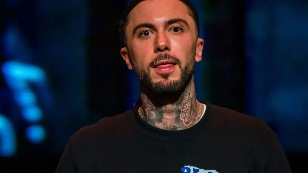 Malik Montana, z tatuażami na szyi, pokazuje język. Ile lat ma Malik Montana?