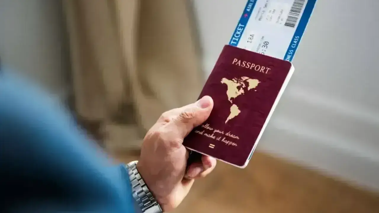 Dłoń trzyma paszport i bilet lotniczy. Czy na Cypr potrzebny jest paszport? Sprawdź przed podróżą!