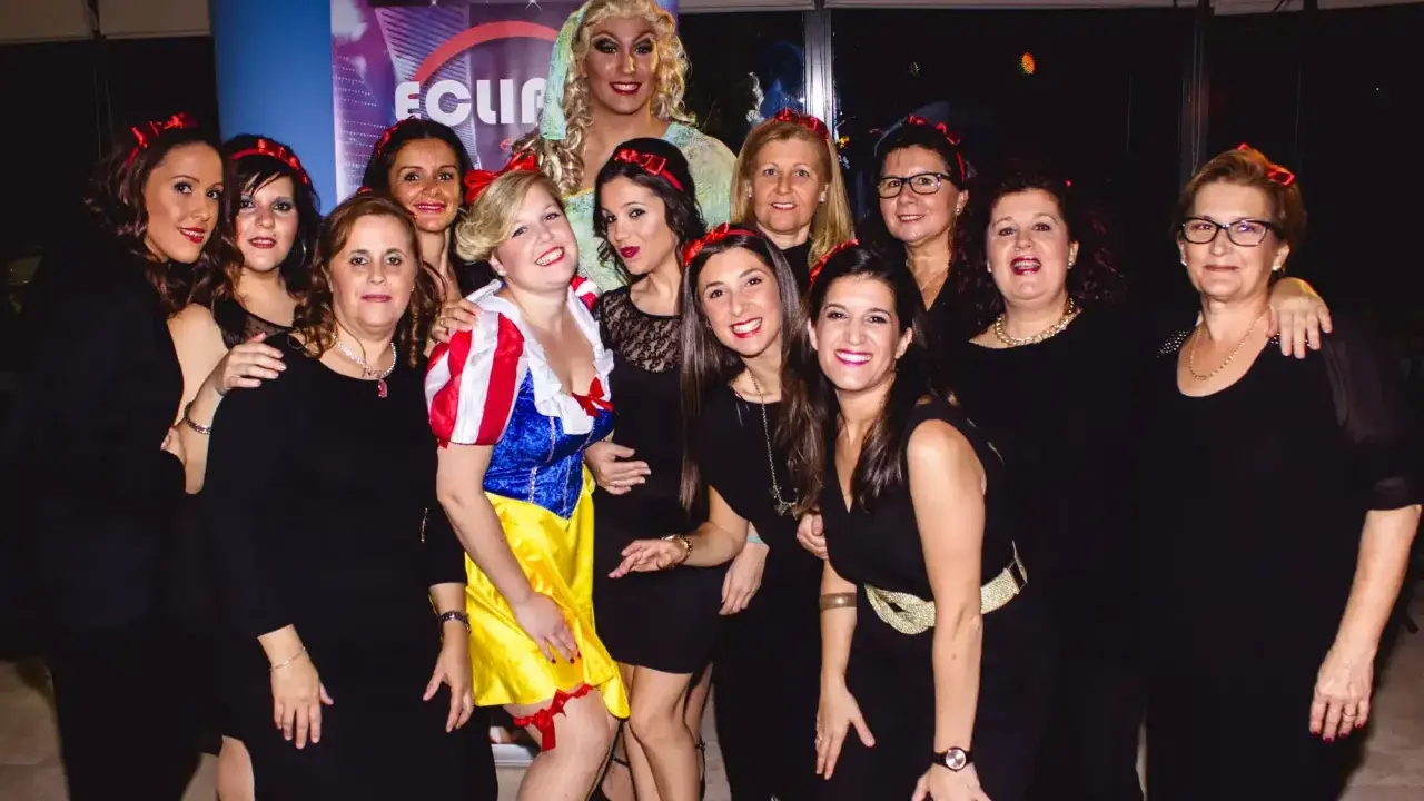 Grupo de mujeres celebrando una despedida de soltero con disfraces, una de ellas vestida de Blancanieves.