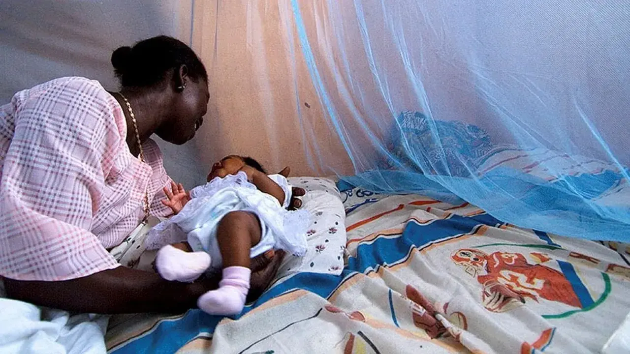 Mor och barn under myggnät, skyddade från malaria. Bali är en plats där kampen mot malaria fortsätter.