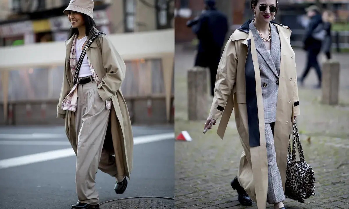 Due donne con trench eleganti. La prima con cappello a secchiello e pantaloni ampi, la seconda con blazer a quadri. Si può mettere il trench di sera per un look chic.