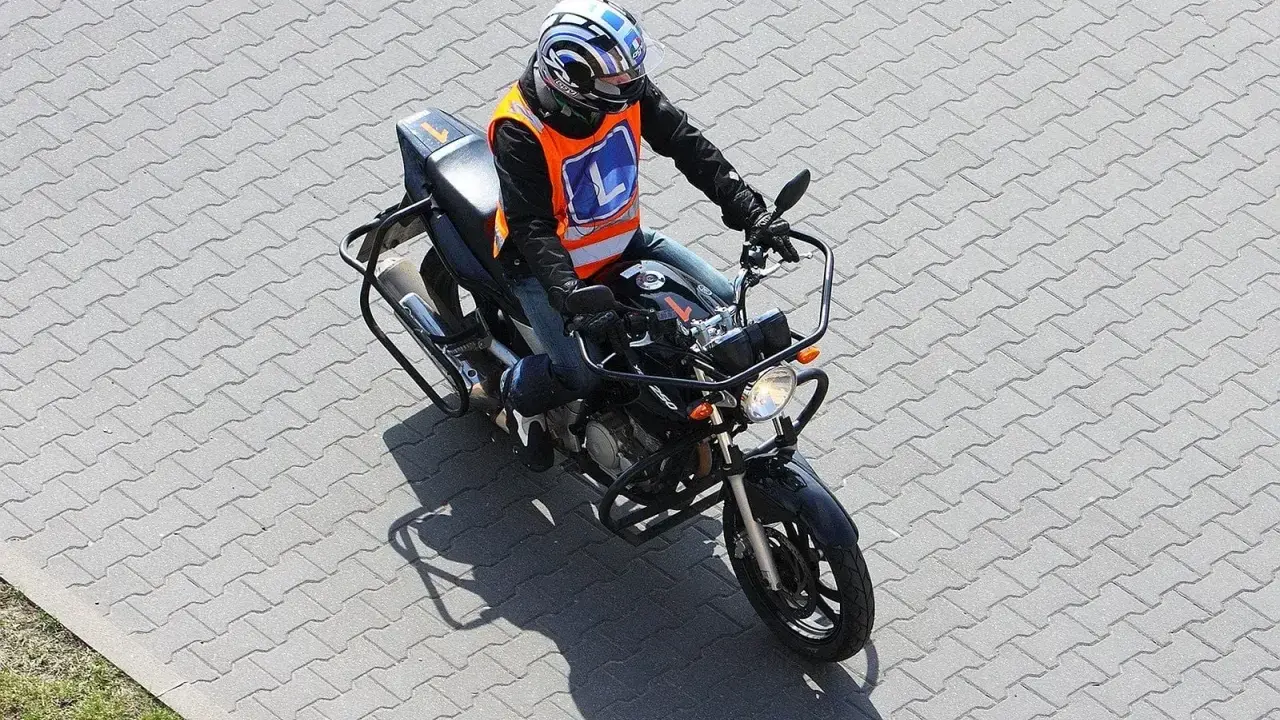 Motocyklista w kamizelce z literą "L" na placu manewrowym. Czy to nauka jazdy na motorze o pojemności 250cc, by zdobyć a2 prawo jazdy?