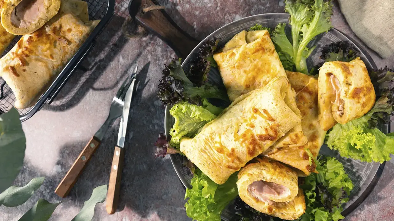Herzhafte Pfannkuchen gefüllt mit Schinken und Käse, serviert mit frischem Salat. Ein Genuss für jeden Gaumen!