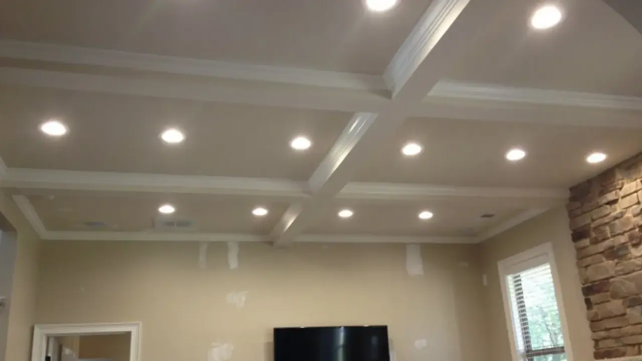 Elegancka wnęka na led w suficie z kasetonami i ozdobnymi listwami, tworząca nowoczesną aranżację wnętrza.