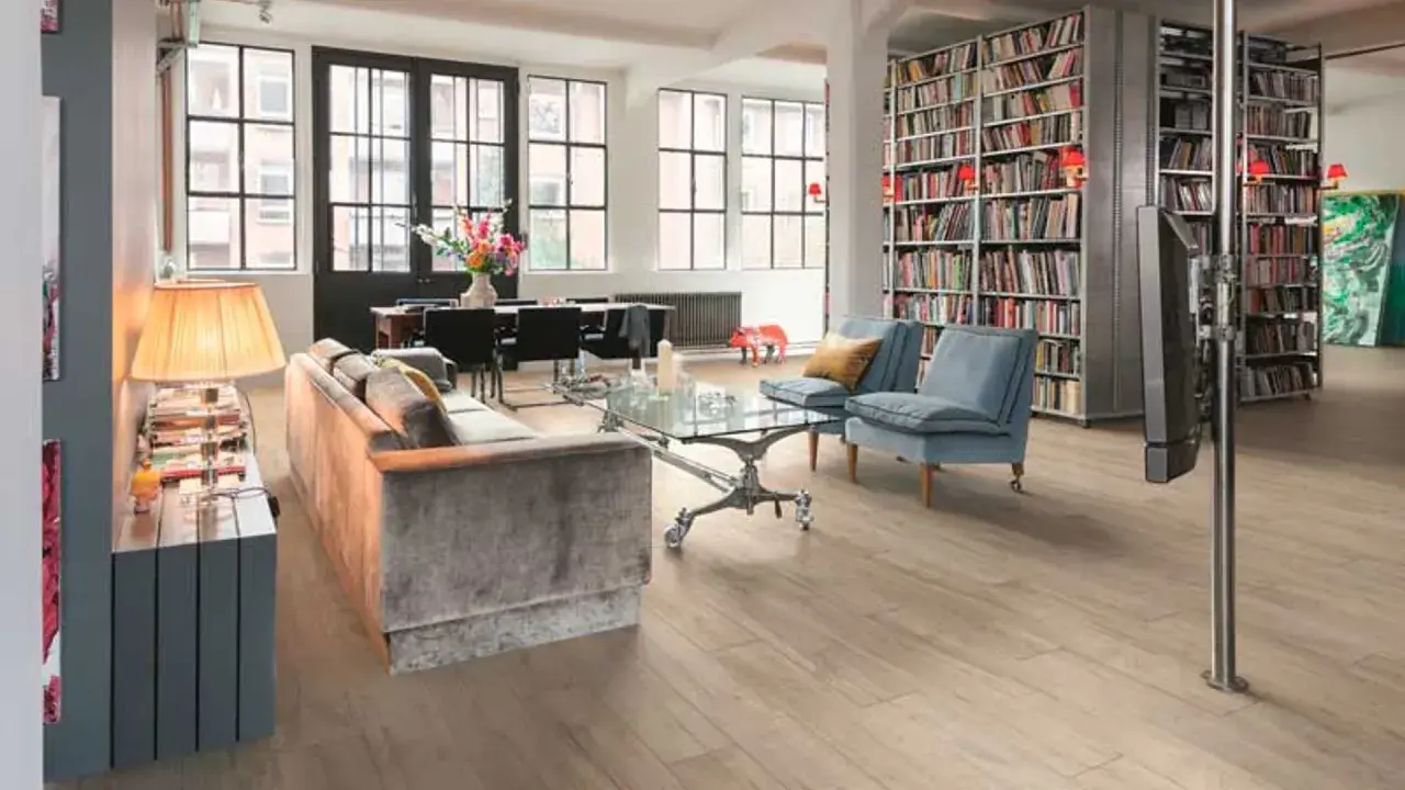 Estanterías llenas de libros ofrecen fantásticas ideas para colocar libros en un salón moderno con sofás, mesa de centro y comedor.