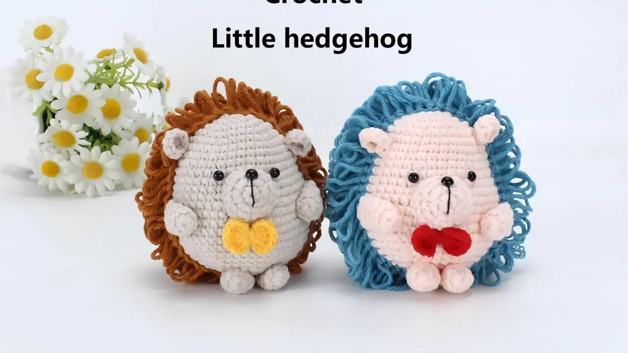Dos adorables erizos de crochet, uno beige con pajarita amarilla y otro rosa con pajarita roja, posan junto a un ramo de margaritas.