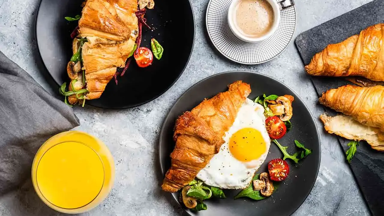 Typowe amerykańskie śniadanie: croissant z jajkiem sadzonym, pomidorkami i grzybami, do tego kawa i sok.