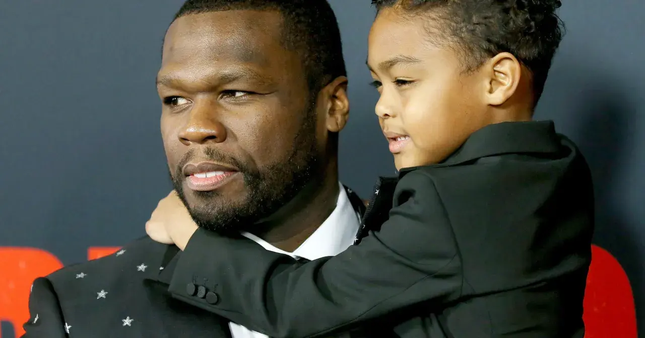 50 Cent z synem, chłopiec w czarnym garniturze przytula się do ojca.