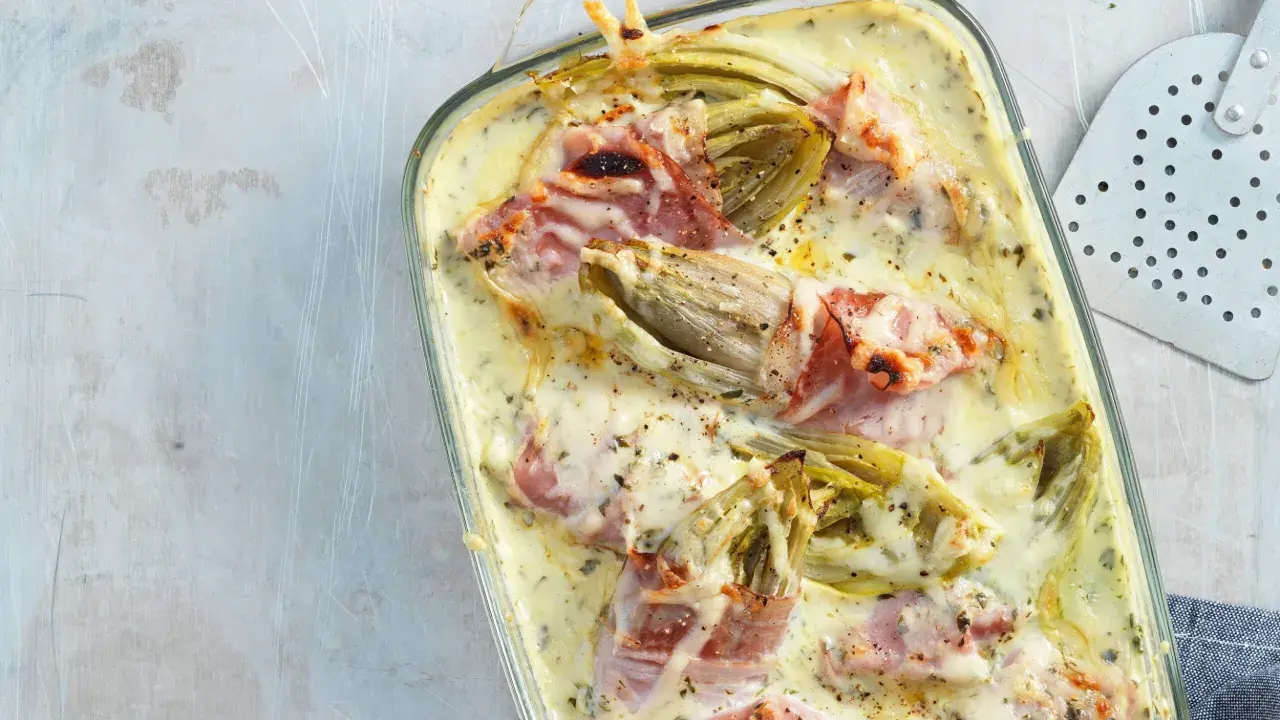 Überbackener Chicorée mit Schinken in cremiger Sauce, ein köstliches Gericht, das Lust auf mehr Chicorée-Rezepte macht.