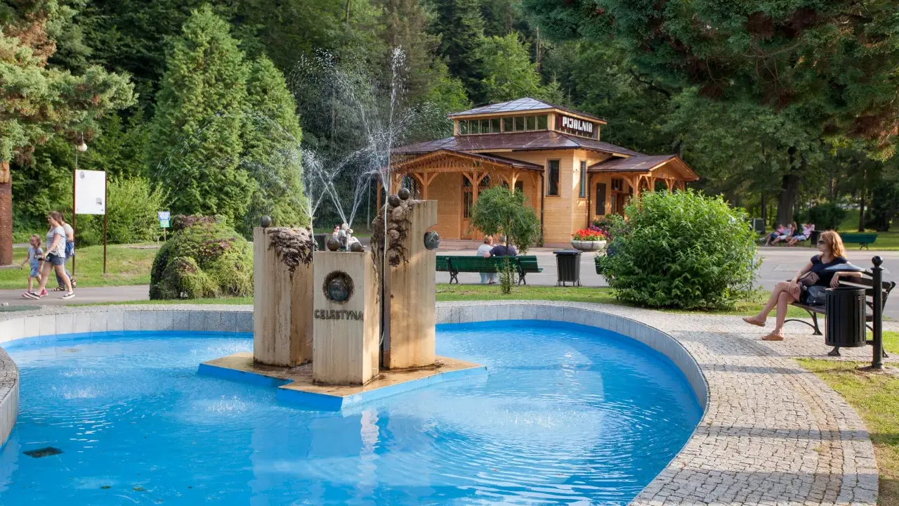 Uzdrowiskowy park w Rymanowie Zdroju z pijalnią i fontanną Celestyna. Sanatoria w tle.