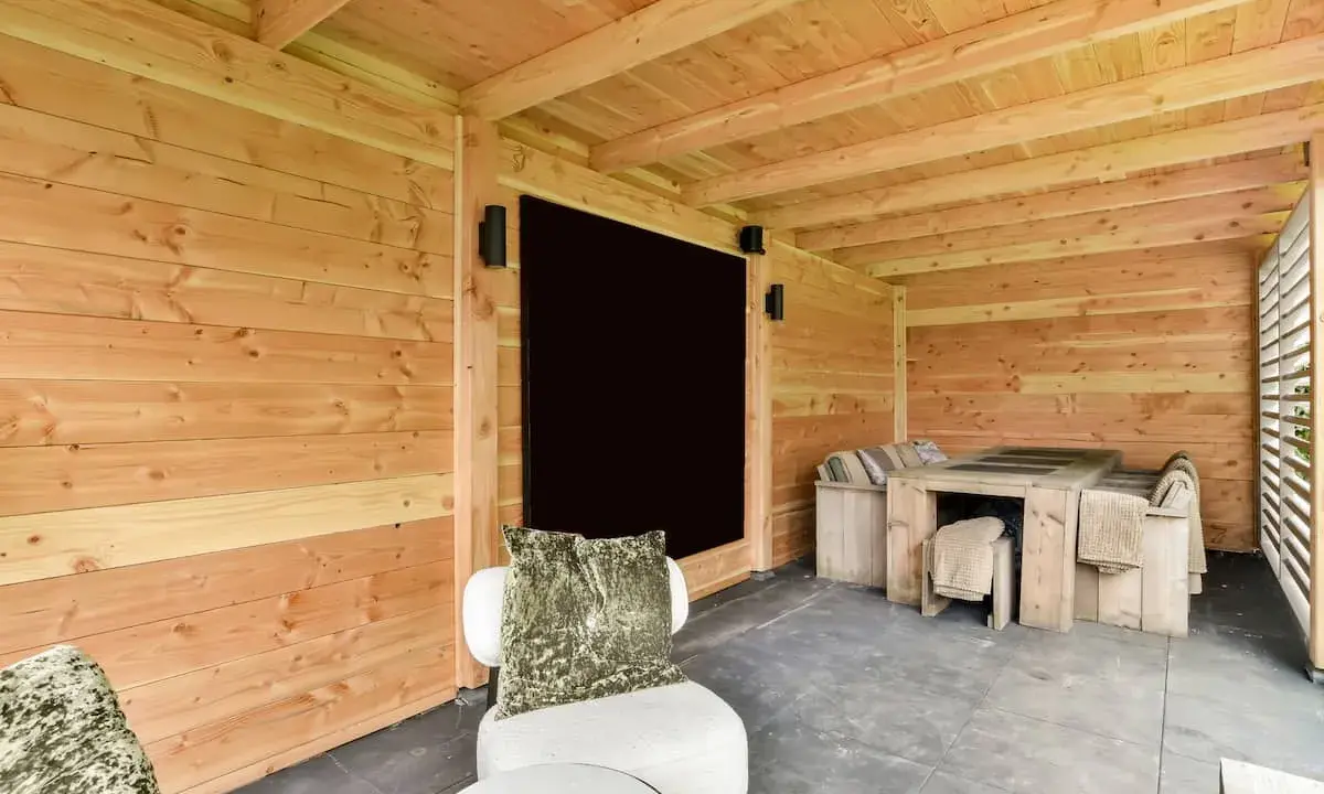 Un'accogliente dependance in legno con tavolo e sedute, perfetta per idee di relax all'aperto.