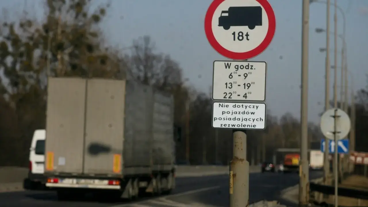 Znak zakazu wjazdu dla pojazdów o masie powyżej 18 ton w określonych godzinach. Czy tiry mogą jeździć w niedzielę? Zależy od zezwolenia.