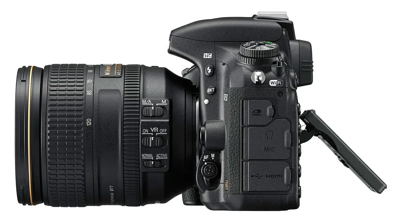 Nikon D750 test: aparat z obiektywem 24-120 mm, widoczne przyciski sterowania, Wi-Fi, HDMI i wejście mikrofonowe.
