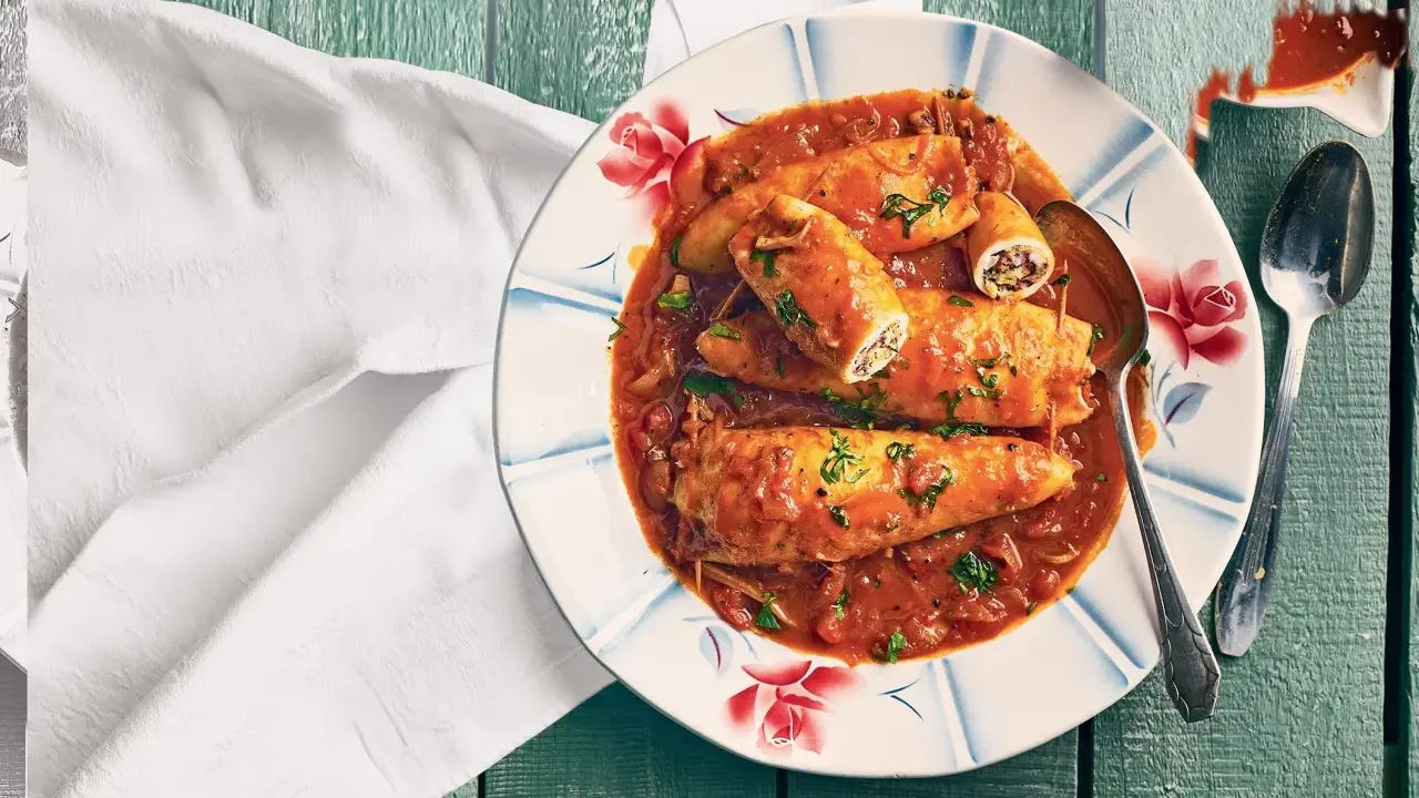 Assiette de calamars farcis à la sauce tomate, une recette encornet tomate savoureuse, garnie de persil frais.