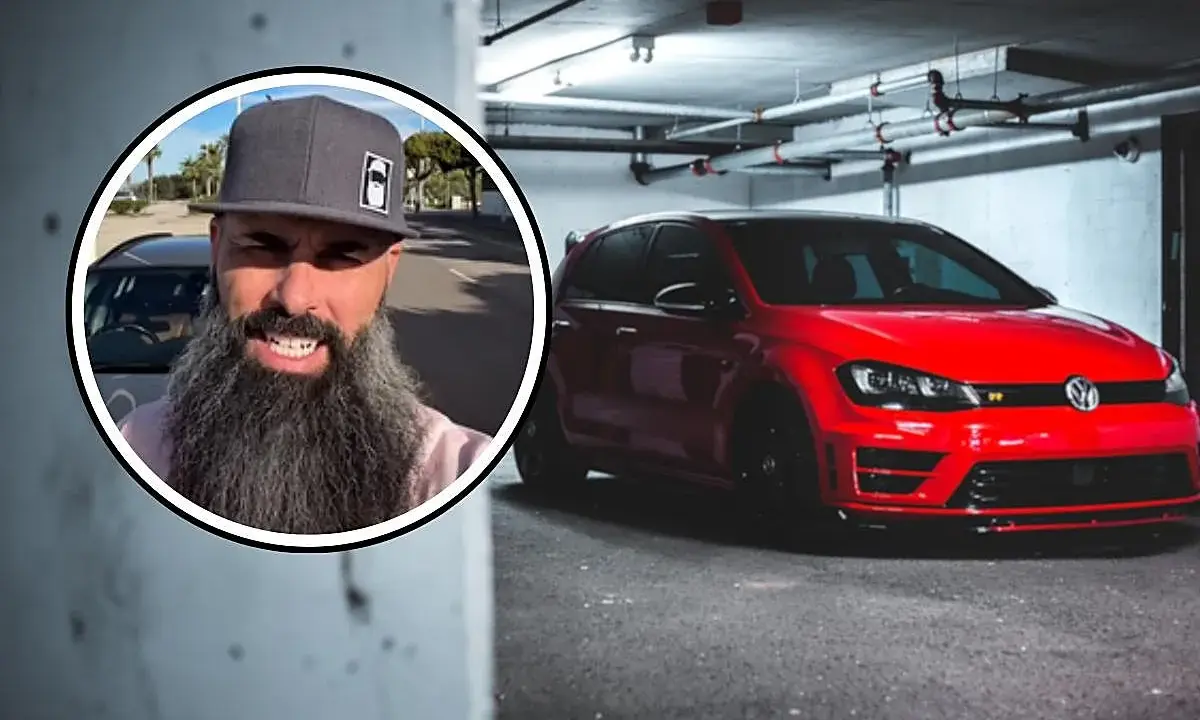Hombre con barba y gorra junto a un Volkswagen Golf rojo, el coche más robado en España.