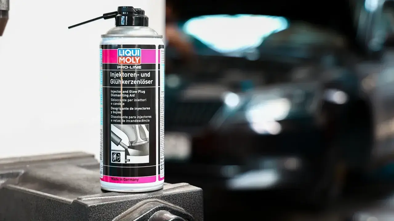Puszka preparatu do czyszczenia wtryskiwaczy Liqui Moly na tle rozmazanego silnika.