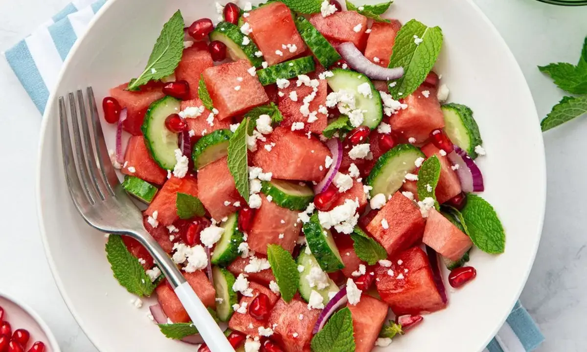Salade estivale de pastèque, concombre, feta émiettée, grenade et menthe fraîche. Un délice rafraîchissant.