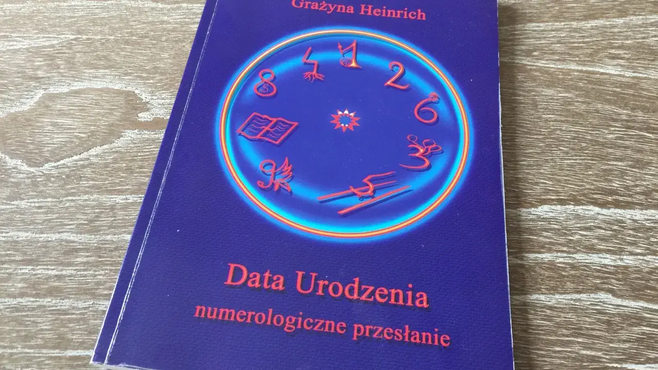 Okładka książki "Data Urodzenia numerologiczne przesłanie" Grażyny Heinrich. Centralny element to okrąg z cyframi i symbolami, sugerujący analizę liczby numerologicznej.
