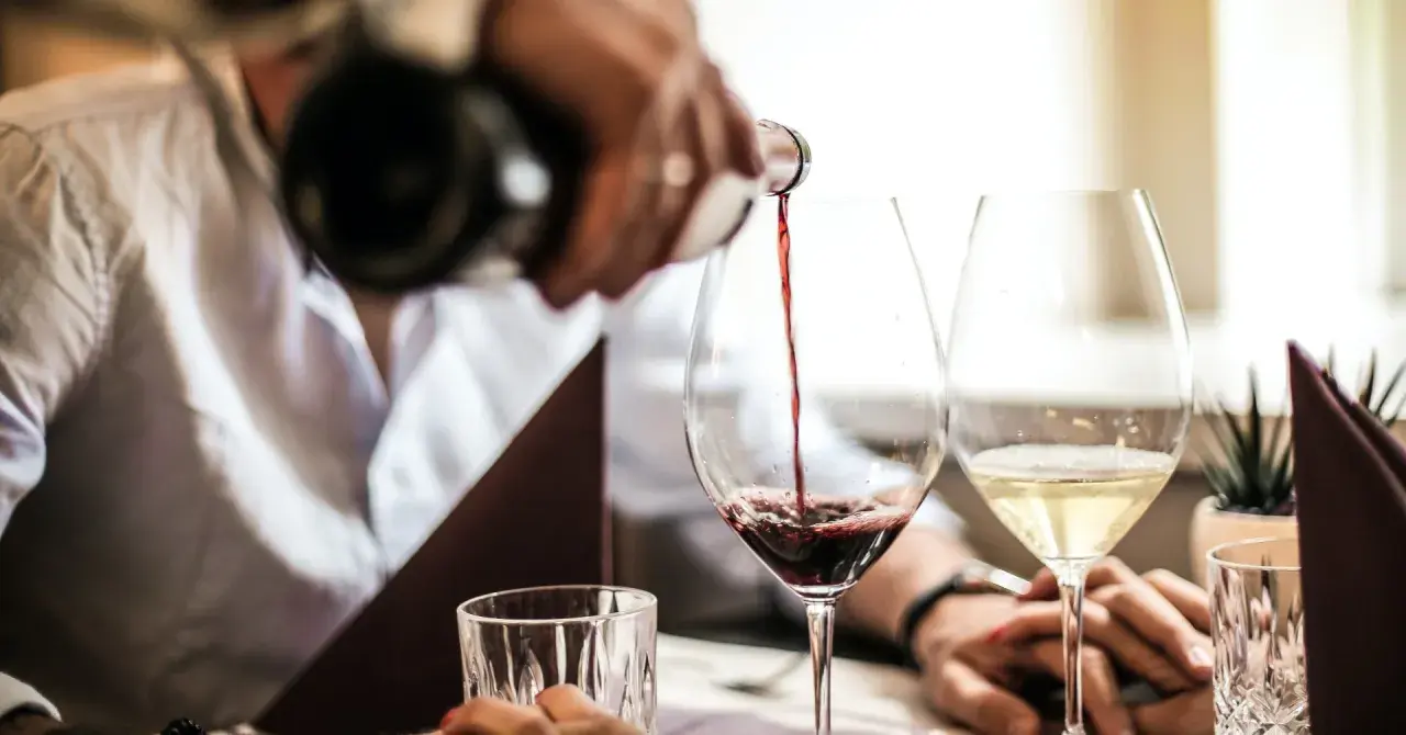 Servicio de vino tinto en la finca la malcriada dulce. Copas de vino y agua en una mesa elegante.
